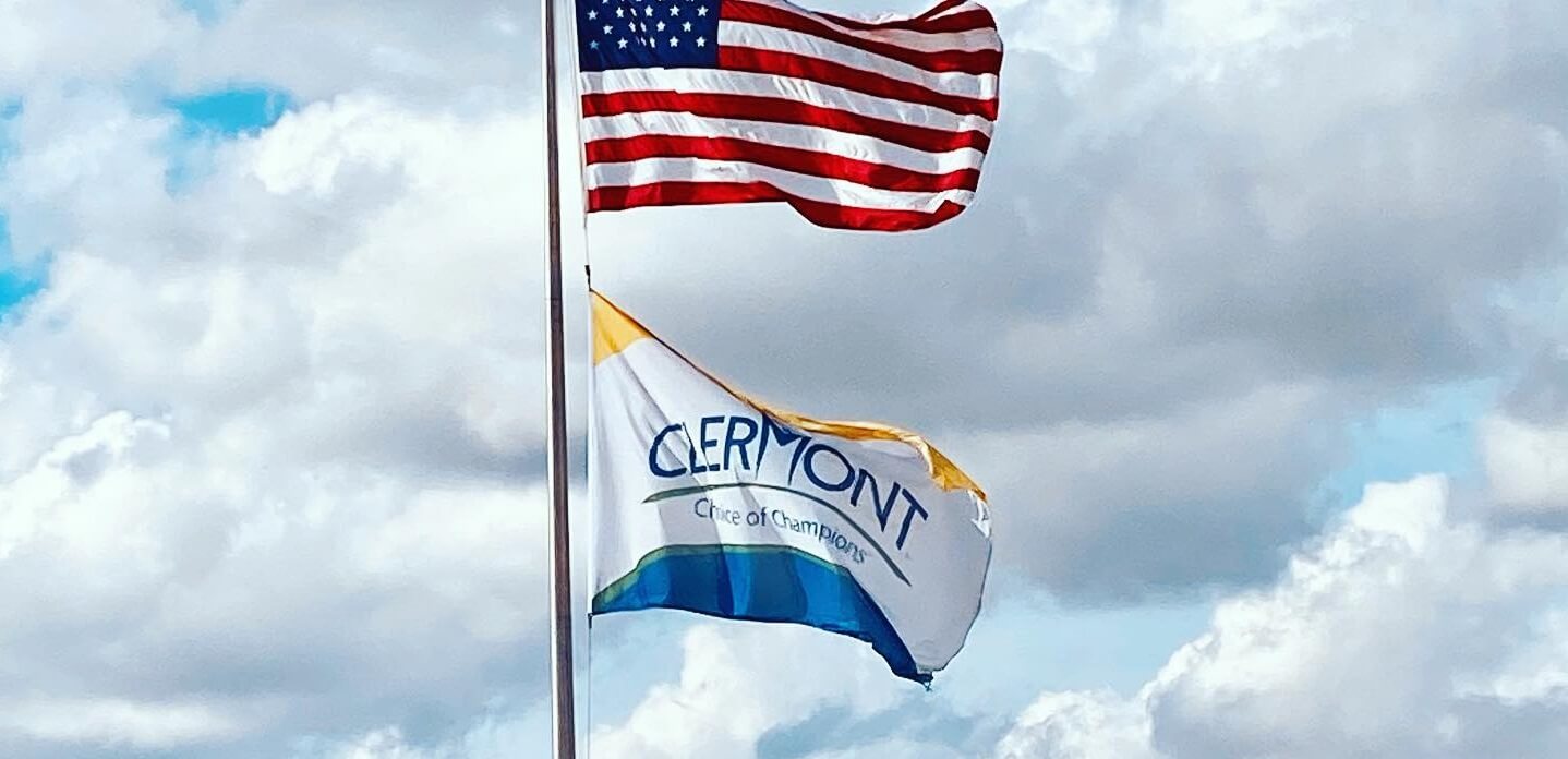Photo of American flag above Clermont city flag.