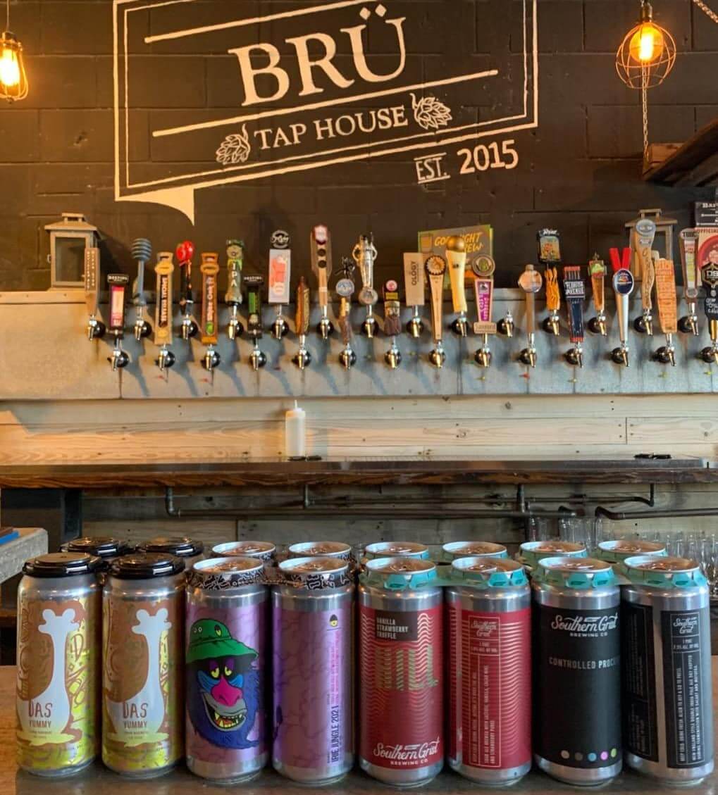Photo inside Bru Tap House brewery showing beer cans and taps.